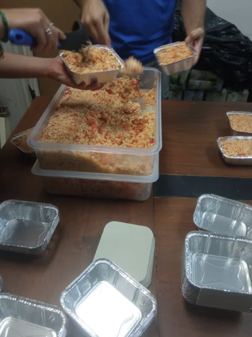 Community meal preparation with trays of food